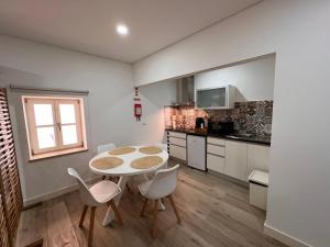 a kitchen with a table and chairs in a room at Pátio 29 - Guest House in Viana do Castelo +50 photos