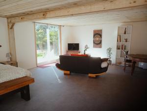 sala de estar con sofá y TV en La Canette de Phil - Chambre d'hôtes - Hébergement indépendant - vue sur piscine, en Samatan