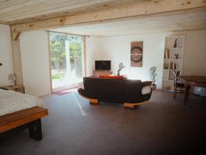 a living room with a couch and a television at La Canette de Phil - Chambre d'hôtes, Indépendante - Vue sur piscine in Samatan