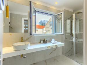 y baño con lavabo y ducha acristalada. en Irini Luxury Rooms en Split