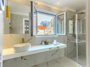 a bathroom with a sink and a glass shower at Irini Luxury Rooms in Split