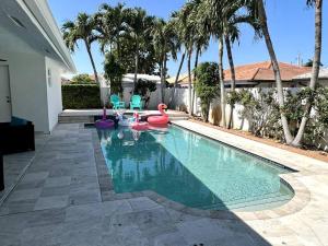 uma piscina com cisnes e cadeiras numa casa em Sunny Getaway: Relaxing Miami Home em Tamiami