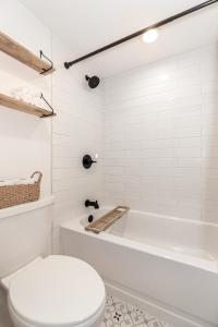 a white bathroom with a tub and a toilet at Iron Horse C3013 condo in Winter Park