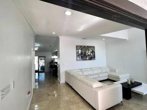 uma sala de estar com um sofá branco e uma mesa em Sunny Getaway: Relaxing Miami Home em Tamiami