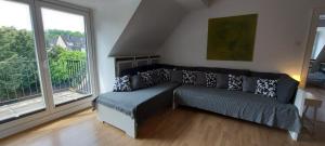 uma sala de estar com um sofá e uma grande janela em AlleeSuite, Nähe Messe, RÜ, Baldeneysee, Zentral, NETFLIX em Essen
