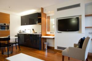 a kitchen with a table, chairs and a television at Blueprint Living Apartments -Turnmill Street in London