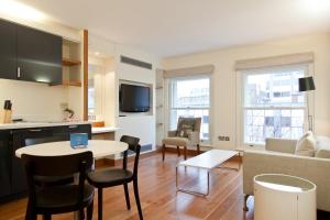 a kitchen and living room with a table and chairs at Blueprint Living Apartments -Turnmill Street in London