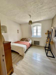 una camera da letto con un letto e una finestra di Notre Dame des Anges DUPLEX a Rustrel