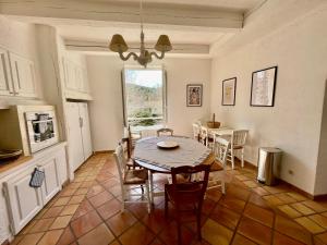 una cucina e una sala da pranzo con tavolo e sedie di Notre Dame des Anges DUPLEX a Rustrel