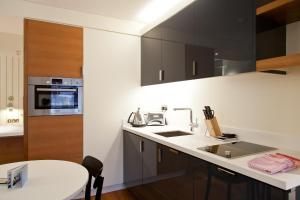 a kitchen with a sink, stove, and refrigerator at Blueprint Living Apartments -Turnmill Street in London