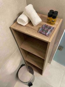 una pequeña estantería de madera con toallas y espejo en Designed Central Apartment, en Volos