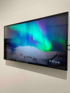TV de pantalla plana colgada en la pared en Designed Central Apartment, en Volos
