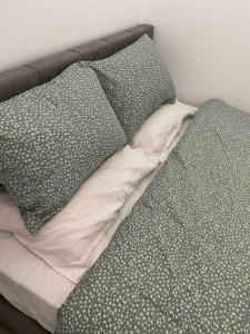 Una cama sin hacer con dos almohadas encima. en Designed Central Apartment, en Volos