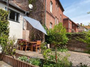 a table and chairs with an umbrella in a garden at Ferienwohnung Bad Freienwalde in Bad Freienwalde