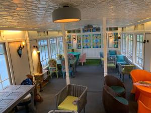 un restaurante con mesas, sillas y ventanas en Messiah’s Ark, en Srinagar