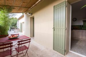 une porte menant à une terrasse avec une table et des chaises. dans l'établissement maison entière de village Fontvieille avec piscine, à Fontvieille 8 autres photos