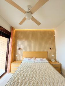 Schlafzimmer mit einem Bett und einem Deckenventilator in der Unterkunft PANORAMIC in Benidorm