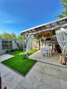 um pátio com uma mesa branca e cadeiras sob uma pérgola em Ubytování Hrušky em Hrušky