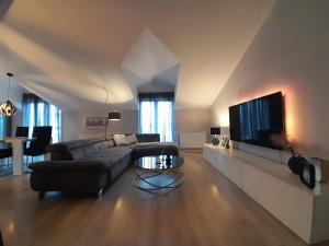 een woonkamer met een bank en een flatscreen-tv bij Luxury Apartment Mare in Brodarica