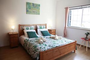 1 dormitorio con 1 cama grande con almohadas azules y blancas en Casa Do Shon, en Óbidos
