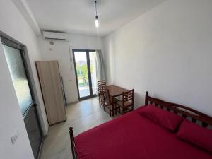 - une chambre avec un lit, une table et des chaises dans l'établissement Sar Hotel, Velipojë, à Velipojë