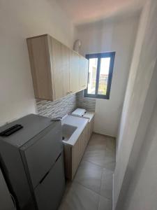 a small kitchen with a sink and a refrigerator at Sar Hotel, Velipojë in Velipojë