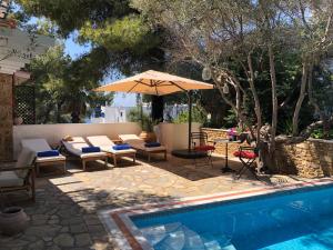 a patio with an umbrella and a swimming pool at Villa eco Electra in Nikiti