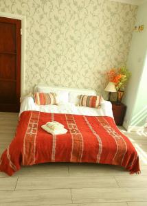 ein Schlafzimmer mit einem Bett mit einer roten Decke in der Unterkunft Beautiful Double En-suite Room, separate entrance, Ilford, Central line Gants Hill, free parking in Ilford