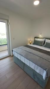 シベニクにあるVilla Adriatic Sunriseの大きな窓付きの客室の大型ベッド1台分です。