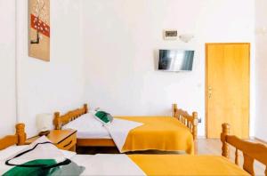2 camas en una habitación con sábanas amarillas en Apartmani Račić, en Split