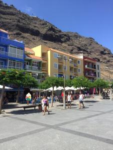 a group of people walking on a street near buildings at Tazacorte Beach and also Luz y Mar apartments in Puerto