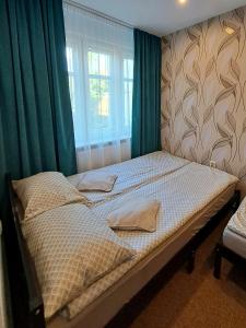 un letto in una camera da letto con tende verdi e finestra di 7 Levél Central Apartments a Miercurea-Ciuc