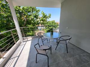 a patio with a table and chairs on a balcony at MT APARTMENTS SUNSET in Neoi Epivates