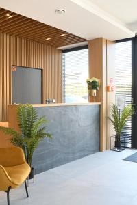 an office with a reception desk and two plants at Hotel Parrot in Raszyn