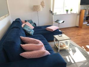 ein blaues Sofa mit Kissen darauf im Wohnzimmer in der Unterkunft Apartament Na Wydmie in Ustka