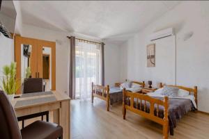 1 dormitorio con 2 camas, mesa y escritorio en Apartmani Račić, en Split