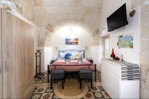 um quarto com uma cama com uma mesa e cadeiras em Chiarina rooms 2 em Polignano a Mare