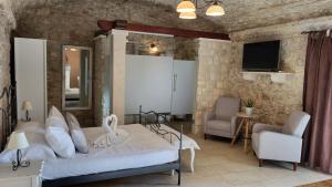 una camera con letto, divano e TV di Stone House Apartments Didini Dvori Lumbarda a Lumbarda (Lombarda)