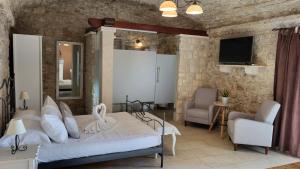 a bedroom with a bed and a couch and a tv at Stone House Apartments Didini Dvori Lumbarda in Lumbarda