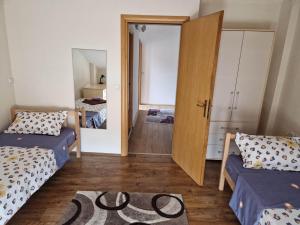 a room with two beds and a door to a bedroom at Town Square House in Gevgelija