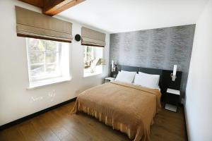 a bedroom with a bed and two windows at Nora Sky in Nida