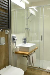 W łazience znajduje się biała umywalka i prysznic. w obiekcie Hotel Parrot w Raszynie