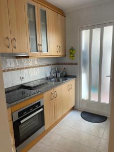 a kitchen with wooden cabinets and a sink at Holiday Home Amari - Residencia Albatros in Los Alcázares