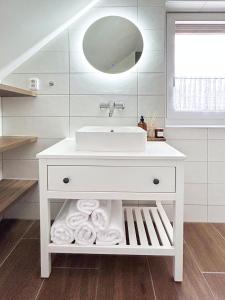 a white bathroom with a sink and a mirror at Apartmán Na vinařské stezce in Velké Bílovice