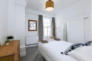 1 dormitorio con 2 camas y ventana en Peaceful Apartment, Private Parking, Long Stay Prices, Close To Uni, Hosp, Centre en Exeter