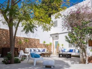 um pátio com um sofá, cadeiras e uma árvore em Luxury White Castle Ibiza em Sant Rafael de Sa Creu