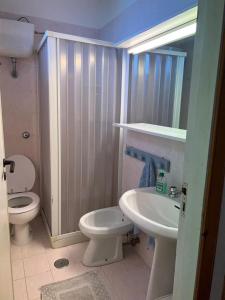 CampomarinoにあるVilla Zefiro - Campomarino di Maruggioの白いトイレと洗面台のあるバスルーム