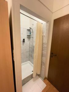 ein Bad mit Dusche und Duschvorhang in der Unterkunft Pension Vera in Wien