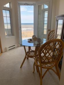 a dining room with a glass table and two chairs at Phare des Dunes Lighthouse in Tracadie