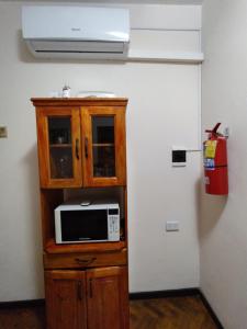 microondas en un armario de madera en una habitación en Departamento Salvador - pleno centro-salta capital en Salta